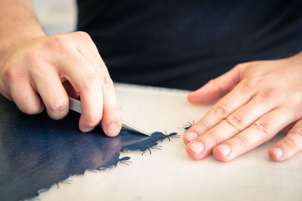 Échenillage à la pince d'un motif en flex bleu marine, atelier K'do Perso à Besançon